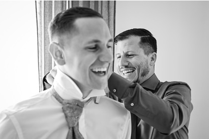 Der Hochzeits Fotograf fotografiert den Bräutigam beim anziehen und fertig machen. - 