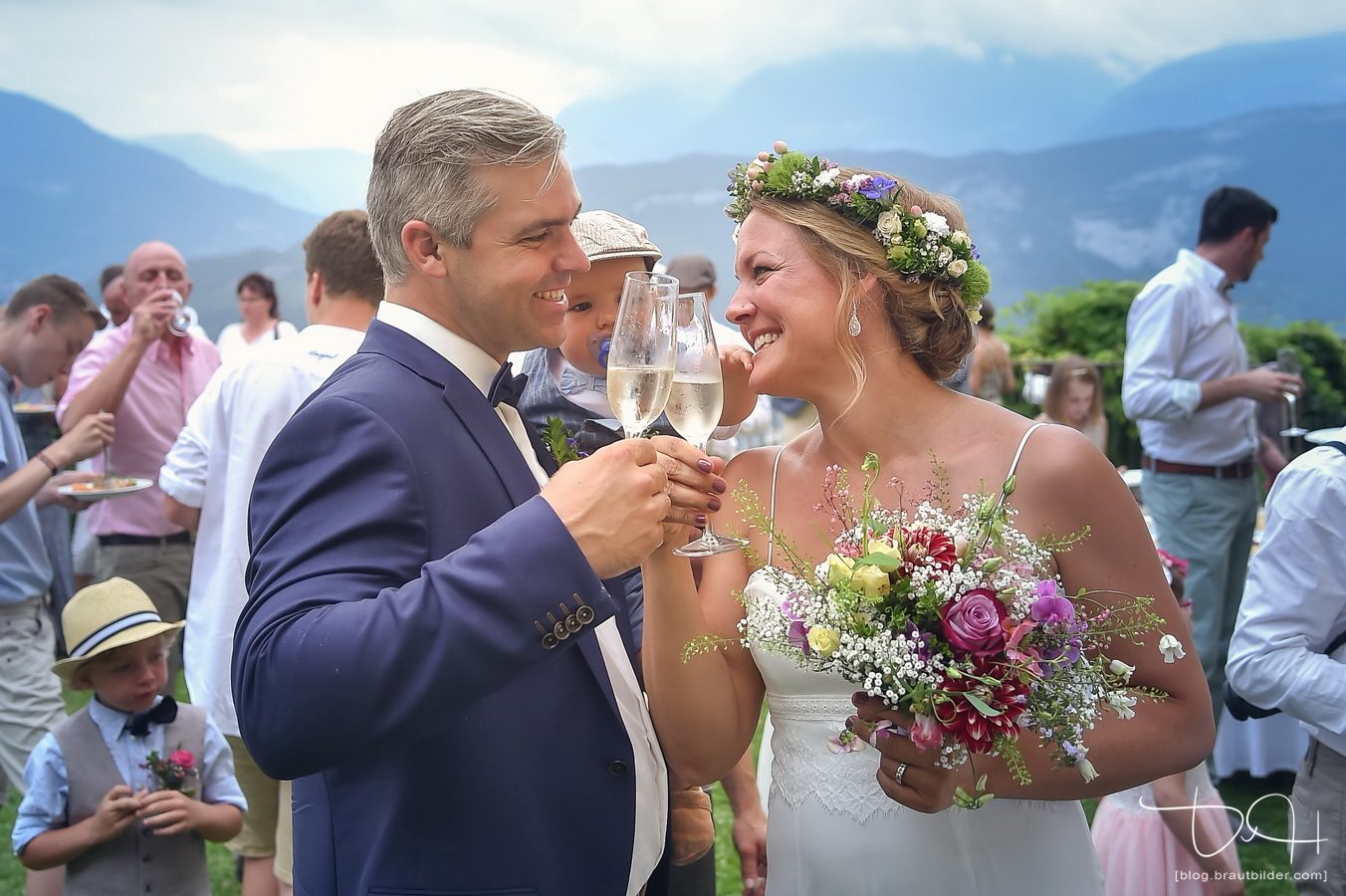 Hochzeitsfotograf am Gardasee - Brautpaar beim Anstoßen vor den Bergen